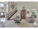 Spacious living room with armoire, fireplace, chandelier, and staircase at 1014 Massey Ct, Greenwood, IN 46143
