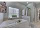 A luxurious soaking tub sits under a glass block window with a separate glass shower at 1014 Massey Ct, Greenwood, IN 46143