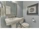 The powder room features elegant pedestal sink, decorative mirror, and stylish wall art at 1014 Massey Ct, Greenwood, IN 46143