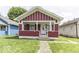 Charming one-story home featuring a red facade, inviting front porch, and well-maintained lawn at 1049 N Tremont N St, Indianapolis, IN 46222