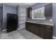 Functional kitchen featuring stainless steel sink, dark cabinetry, open shelves, and tile flooring at 1049 N Tremont N St, Indianapolis, IN 46222