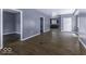 Open-concept living room with hardwood floors, large window, neutral paint, and an adjacent kitchen area at 1049 N Tremont N St, Indianapolis, IN 46222
