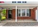 Welcoming covered front porch with brick facade, stylish front door, and decorative landscaping details at 10625 Gathering Dr, Indianapolis, IN 46259