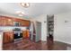 Spacious kitchen with wood cabinets, stainless steel appliances, and view of dining area with pantry at 10625 Gathering Dr, Indianapolis, IN 46259