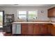 Kitchen showcasing wooden cabinets, stainless steel dishwasher, and bar cart next to exterior access at 10625 Gathering Dr, Indianapolis, IN 46259