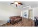 Living room with wood laminate flooring, a ceiling fan, and access to other rooms at 10625 Gathering Dr, Indianapolis, IN 46259