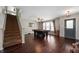 Spacious living room featuring hardwood floors, staircase, billiard table, and abundant natural light at 10625 Gathering Dr, Indianapolis, IN 46259