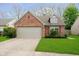 Charming single-story brick home featuring an attached two-car garage and well-maintained landscaping at 11108 Oakridge Dr, Fishers, IN 46038