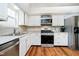Well-lit kitchen features stainless steel appliances, white cabinets, and wood-look floors at 11108 Oakridge Dr, Fishers, IN 46038