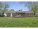 Backyard with a brick home, lawn, and greenery at 1116 Heatherwood Dr, Indianapolis, IN 46241