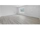 A bedroom with newly installed gray vinyl floors, white walls and trim, and a window with natural light at 1116 Heatherwood Dr, Indianapolis, IN 46241