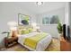A staged bedroom with decorative bed, a window, and wood flooring at 1116 Heatherwood Dr, Indianapolis, IN 46241