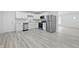 Modern kitchen featuring white cabinets, stainless steel appliances, and gray vinyl flooring at 1116 Heatherwood Dr, Indianapolis, IN 46241