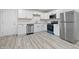 Modern kitchen featuring white cabinets, stainless steel appliances, and gray vinyl flooring at 1116 Heatherwood Dr, Indianapolis, IN 46241