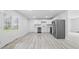 Bright kitchen with stainless steel appliances, white cabinets, and light wood-look flooring at 1116 Heatherwood Dr, Indianapolis, IN 46241