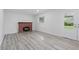 Bright living room with a brick fireplace, window and hardwood style flooring at 1116 Heatherwood Dr, Indianapolis, IN 46241