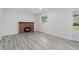 Bright room with a brick fireplace, window and hardwood style flooring at 1116 Heatherwood Dr, Indianapolis, IN 46241
