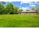 A brick home has a spacious backyard with lush, green lawn at 1171 S Daisy Ln, New Palestine, IN 46163