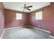 Bedroom featuring neutral carpeting, two windows that provide natural light, and brown color painted walls at 1171 S Daisy Ln, New Palestine, IN 46163