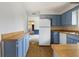 Well-lit kitchen with blue cabinetry, updated appliances, and practical layout at 1171 S Daisy Ln, New Palestine, IN 46163