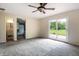 Living room showcasing the open layout, ceiling fan, and sliding glass door to the backyard and a glimpse of the powder room at 1171 S Daisy Ln, New Palestine, IN 46163