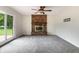 Spacious living room featuring a brick fireplace, ceiling fan, neutral carpeting, and sliding glass door to outside at 1171 S Daisy Ln, New Palestine, IN 46163
