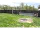 Fenced backyard featuring a swing set and a metal firewood storage rack on a grassy lawn at 125 Howard St, Greenfield, IN 46140