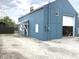 Detached garage with a white door, partial awning, and plenty of parking space at 125 Howard St, Greenfield, IN 46140