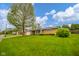 Well-maintained brick home featuring a lush green lawn and mature trees on a sunny day at 1324 Chesterfield Dr, Anderson, IN 46012