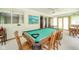 Bright game room with a green felt pool table, windows, ceiling fan, and carpeted flooring at 1324 Chesterfield Dr, Anderson, IN 46012