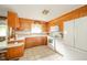 Cozy kitchen featuring wood cabinetry, white appliances, and tiled flooring at 1324 Chesterfield Dr, Anderson, IN 46012