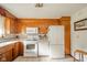A well lit kitchen featuring wooden cabinets, white appliances and tiled floors at 1324 Chesterfield Dr, Anderson, IN 46012