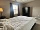 Bright bedroom featuring a window with gray curtains, a ceiling fan, and a dresser at 1328 Sturm Ave, Indianapolis, IN 46202