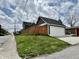 View of the home's detached garage showcasing its white door and adjacent wooden fence at 1328 Sturm Ave, Indianapolis, IN 46202