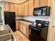 Kitchen with wood cabinets, black appliances and stainless sink at 1328 Sturm Ave, Indianapolis, IN 46202