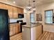 Kitchen featuring a central island, stainless sink, wood cabinets, and modern lighting at 1328 Sturm Ave, Indianapolis, IN 46202