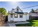 Home exterior featuring white siding, green lawn, and fenced yard at 139 N East St, Pendleton, IN 46064