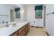 Cozy bathroom featuring a vanity with sink, mirror, patterned wallpaper, and natural light at 1421 Stoney Creek Cir, Carmel, IN 46032