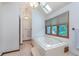 Relaxing bathroom with a tiled tub, bright window, and natural light at 1421 Stoney Creek Cir, Carmel, IN 46032