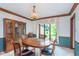 Traditional dining room with wood table, chairs, cabinet, and large window at 1421 Stoney Creek Cir, Carmel, IN 46032