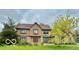 Charming two-story home featuring stone and wood accents, complemented by mature trees and a well-manicured lawn at 1421 Stoney Creek Cir, Carmel, IN 46032