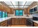 Functional kitchen with wood cabinets, black appliances, and a window providing natural light at 1421 Stoney Creek Cir, Carmel, IN 46032