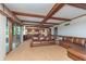 Spacious living room with exposed wood beams, large sliding glass doors, and a large brown leather couch at 1421 Stoney Creek Cir, Carmel, IN 46032