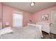 Cozy bedroom featuring a twin bed, hardwood floors, soft pink walls, and a white dresser at 14584 Hinton Dr, Fishers, IN 46037