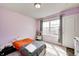 Bright bedroom featuring pink walls, wood floors, and a large window letting in natural light at 14584 Hinton Dr, Fishers, IN 46037