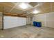 Spacious unfinished two-car garage featuring a white door, utility boxes, and blue trash cans at 14584 Hinton Dr, Fishers, IN 46037