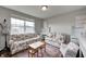 Cozy living room with floral couches, a small desk, table, and a bright window providing ample natural light at 14584 Hinton Dr, Fishers, IN 46037