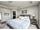 Elegant primary bedroom with a tray ceiling, a rustic wood bed frame, and side tables with a bathroom entrance view at 14584 Hinton Dr, Fishers, IN 46037