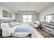The spacious primary bedroom features a tray ceiling, bright natural light, hardwood floors, and stylish, rustic furniture at 14584 Hinton Dr, Fishers, IN 46037