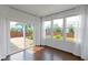 Bright sunroom featuring dark hardwood floors, sliding glass door leading to a brick patio, and multiple windows at 14584 Hinton Dr, Fishers, IN 46037